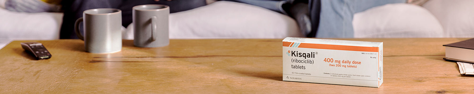 A box of KISQALI on a coffee table.