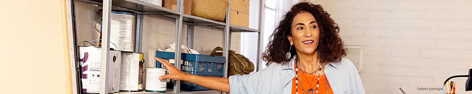 A woman in an art studio selecting a can of paint.