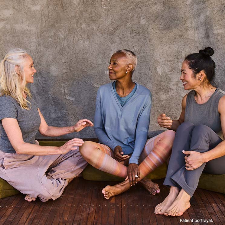 Three women sitting together and having a conversation after a yoga class.